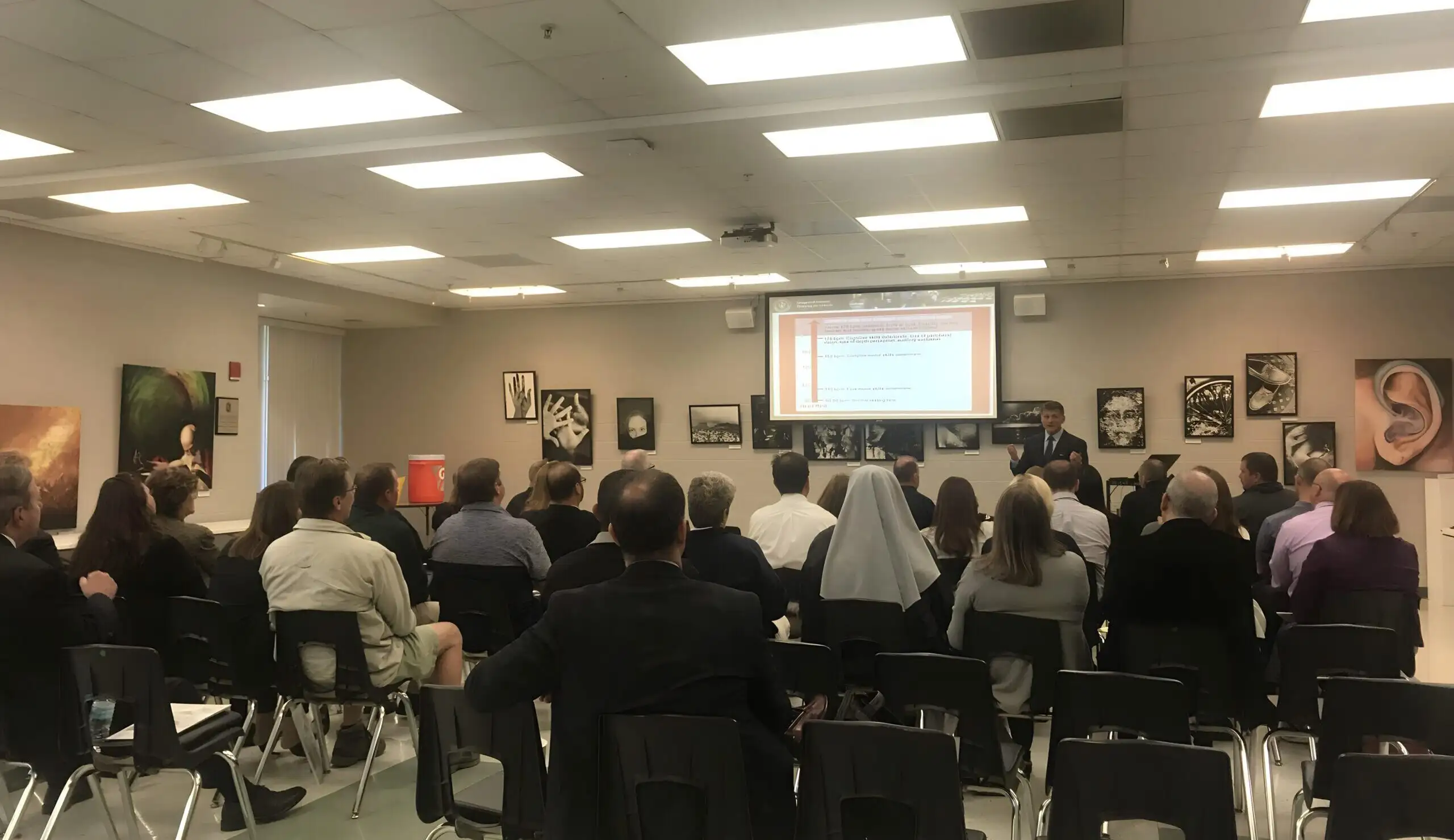 A room of people listening to a presentation at a planning meeting