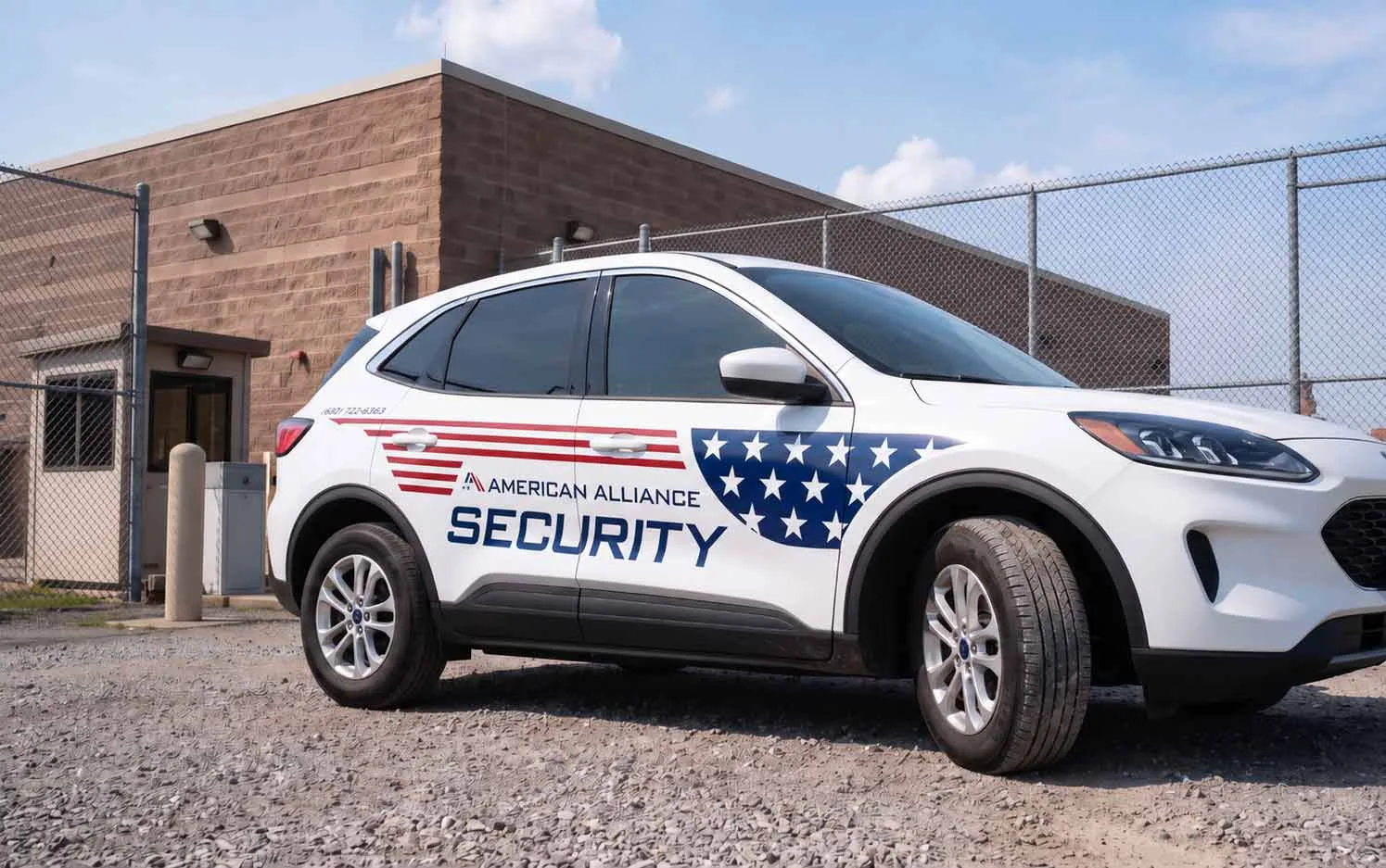 An American Alliance Security patrol vehicle parked at a fenced facility