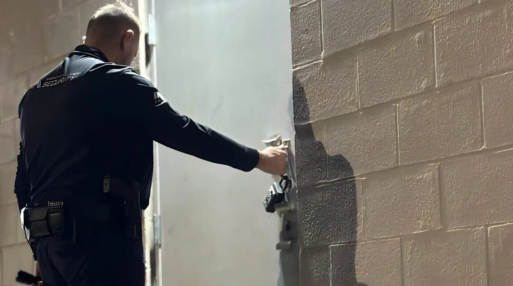 A security officer testing the lock on a building door